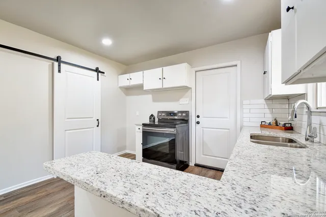 a kitchen with a stove a sink and a refrigerator