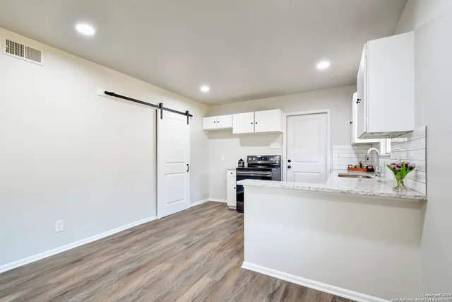 a kitchen with stainless steel appliances a refrigerator and a stove top oven