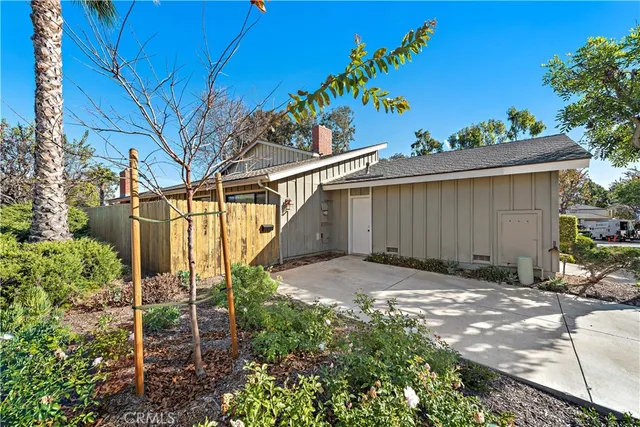 a backyard of a house with plants and outdoor seating