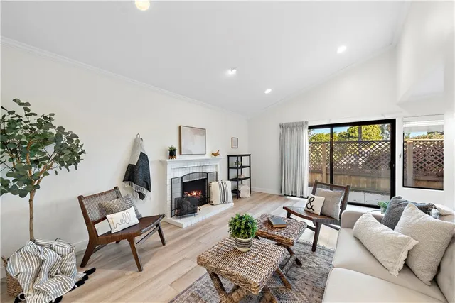 a living room with furniture fireplace and a large window