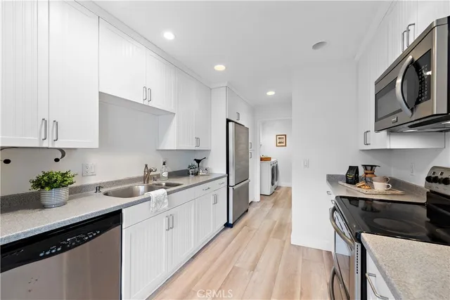 a kitchen with stainless steel appliances a sink stove top oven and cabinets