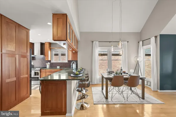 a view of a kitchen with fridge and wooden floors