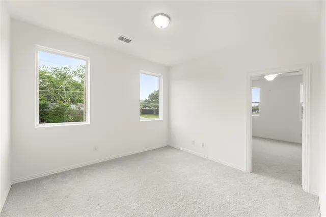 an empty room with windows and closet