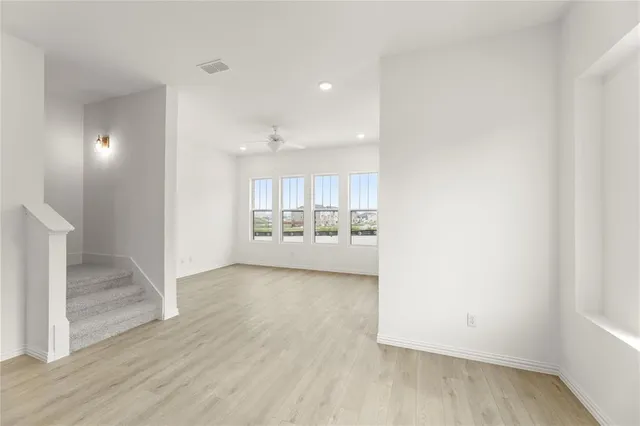 a view of a hallway with wooden floor and a living room