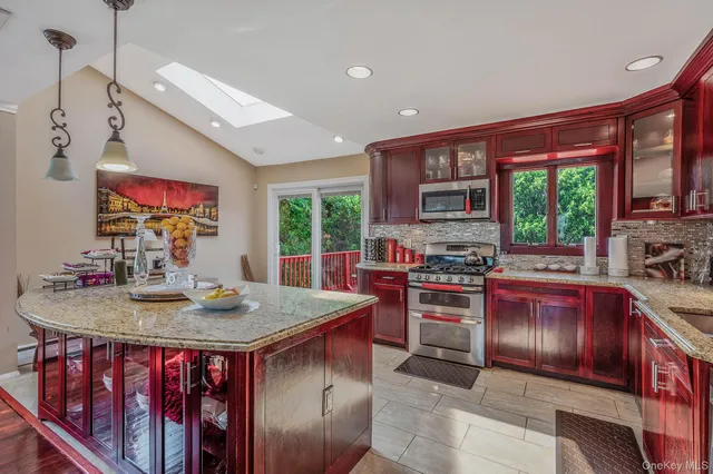 a open kitchen with stainless steel appliances granite countertop a stove top oven a sink and a refrigerator