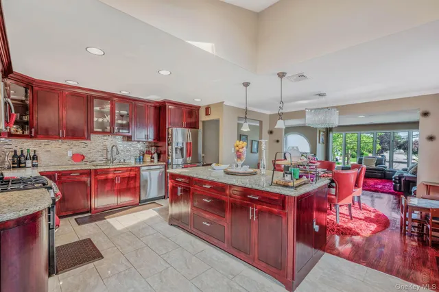 a kitchen with kitchen island granite countertop lots of counter top space and stainless steel appliances