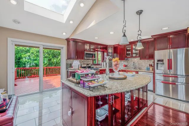 a kitchen with stainless steel appliances granite countertop a sink a stove and a wooden floors