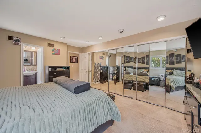 a bedroom with a large bed and a view of living room