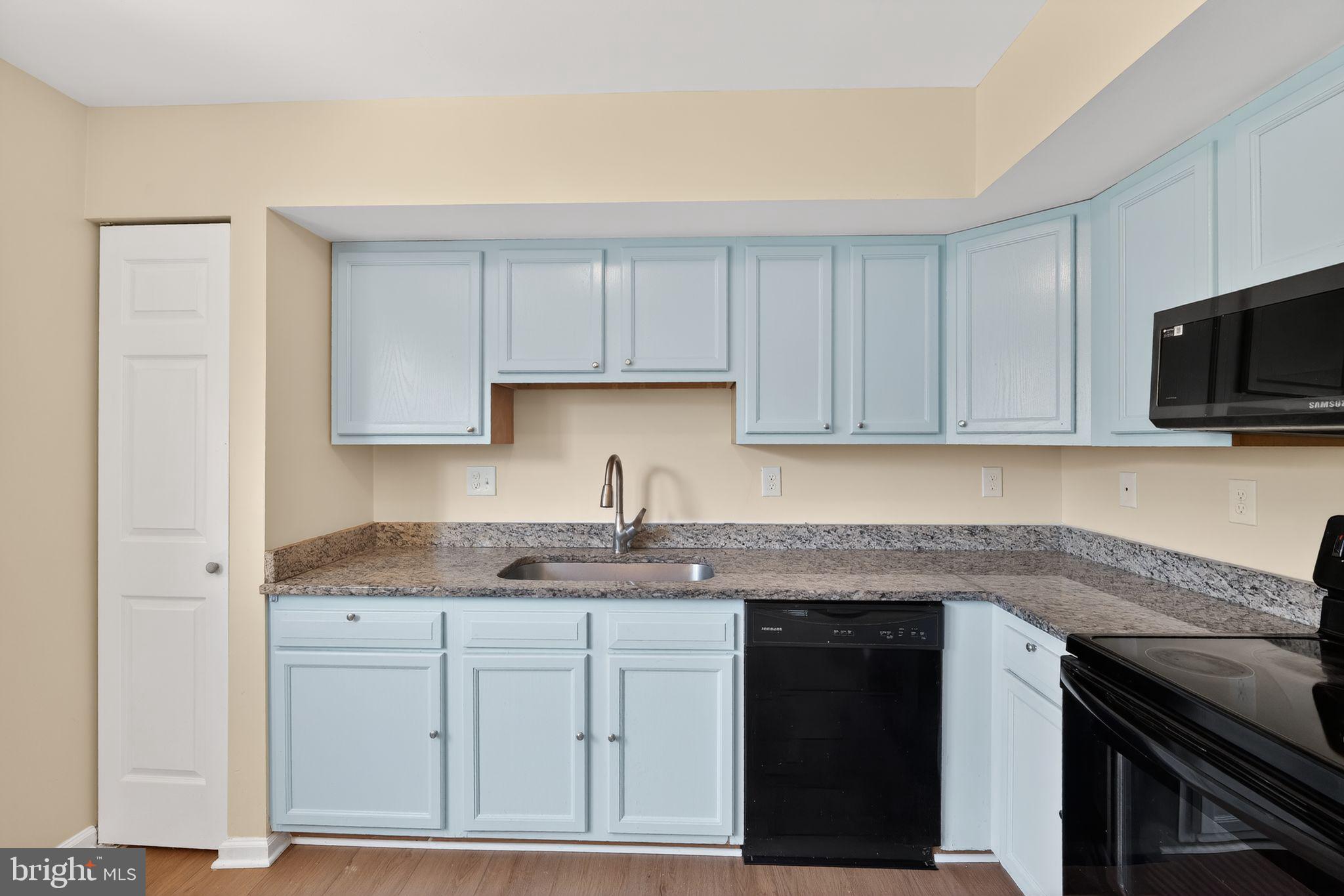 8090 Round Table Court Pasadena, MD 21122 - Photo 16 of 31 a kitchen with granite countertop white cabinets stainless steel appliances and a sink