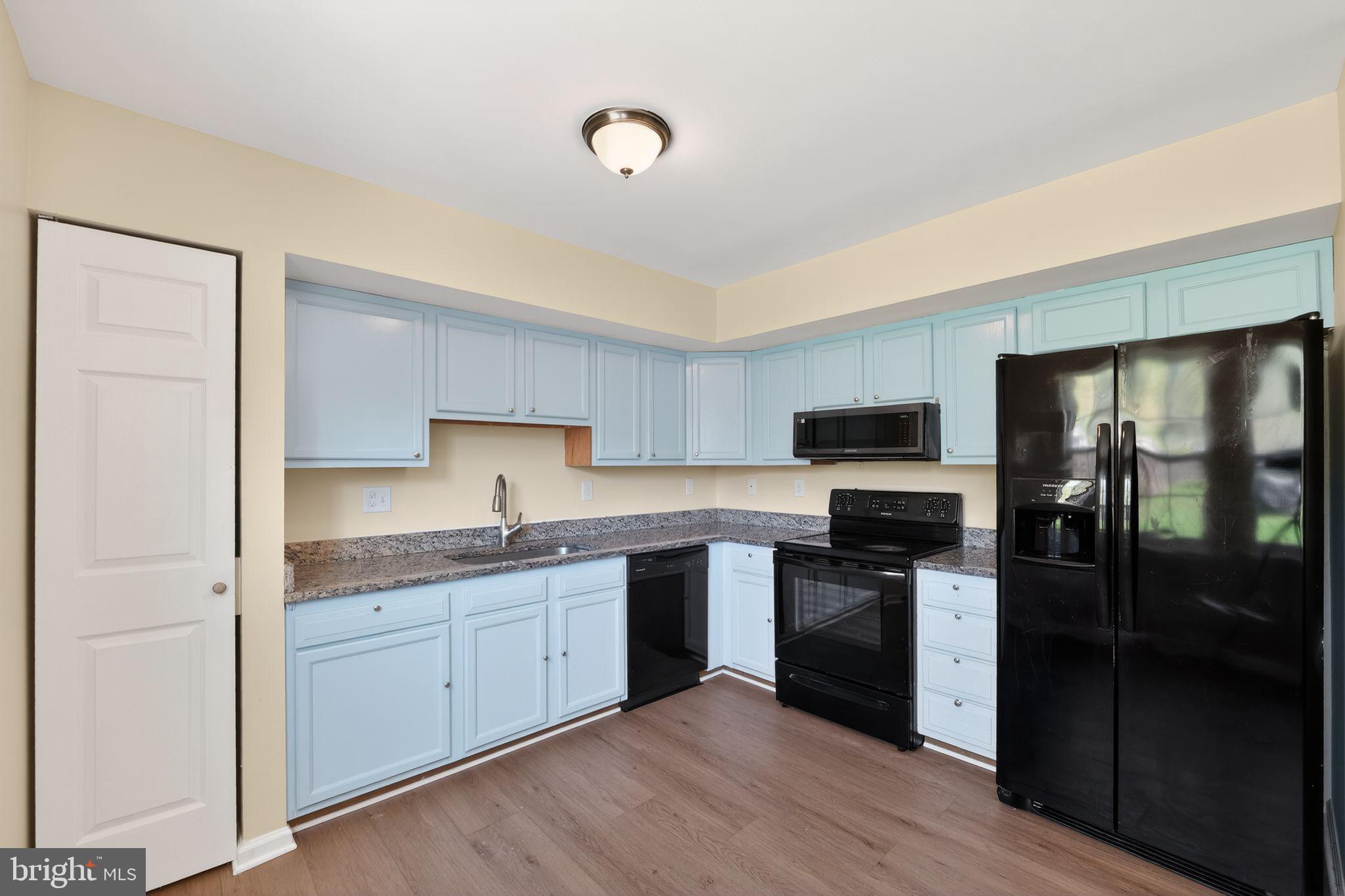 8090 Round Table Court Pasadena, MD 21122 - Photo 18 of 31 a kitchen with a sink a refrigerator and cabinets