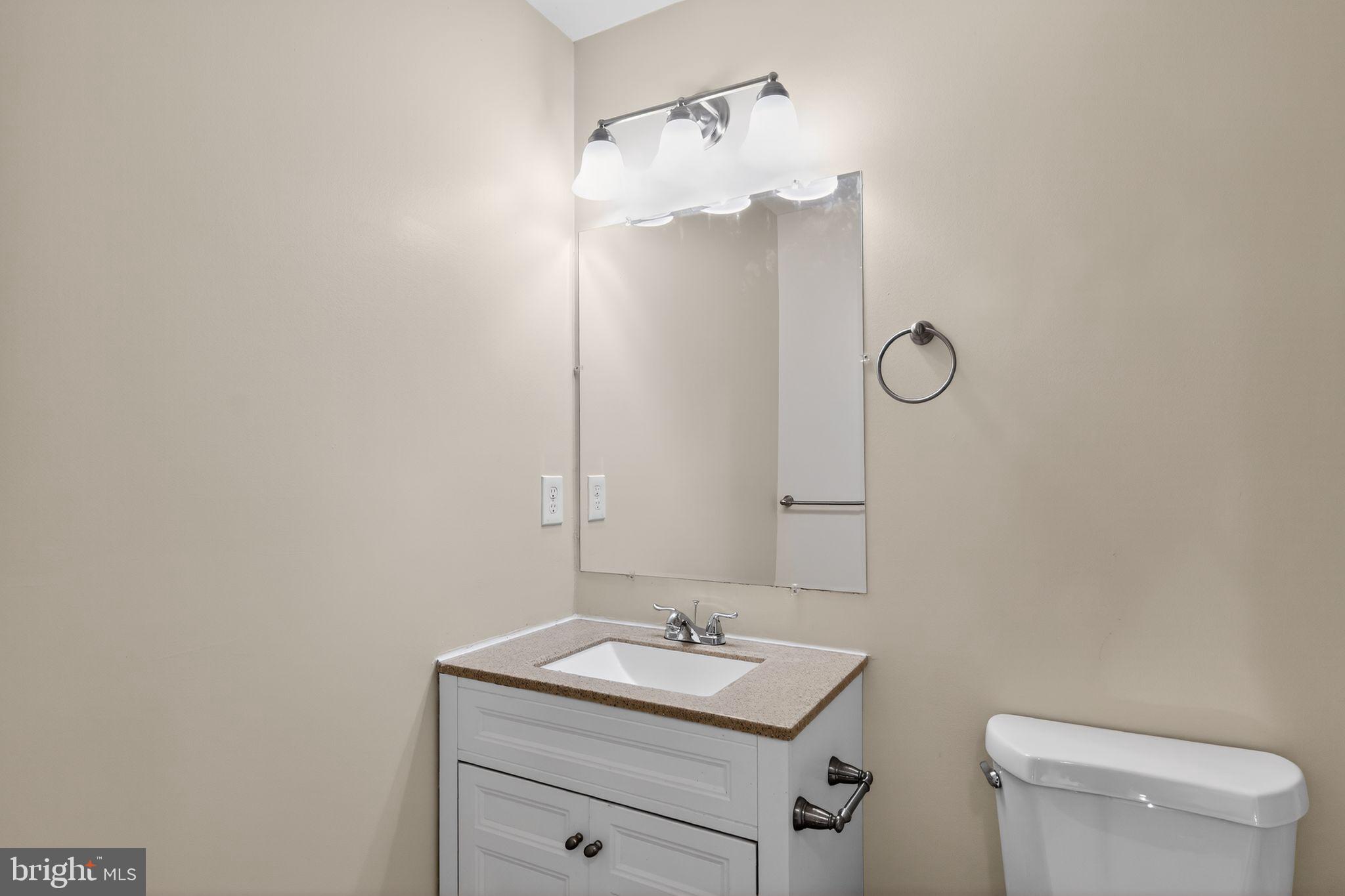 8090 Round Table Court Pasadena, MD 21122 - Photo 26 of 31 a bathroom with a toilet sink vanity and mirror