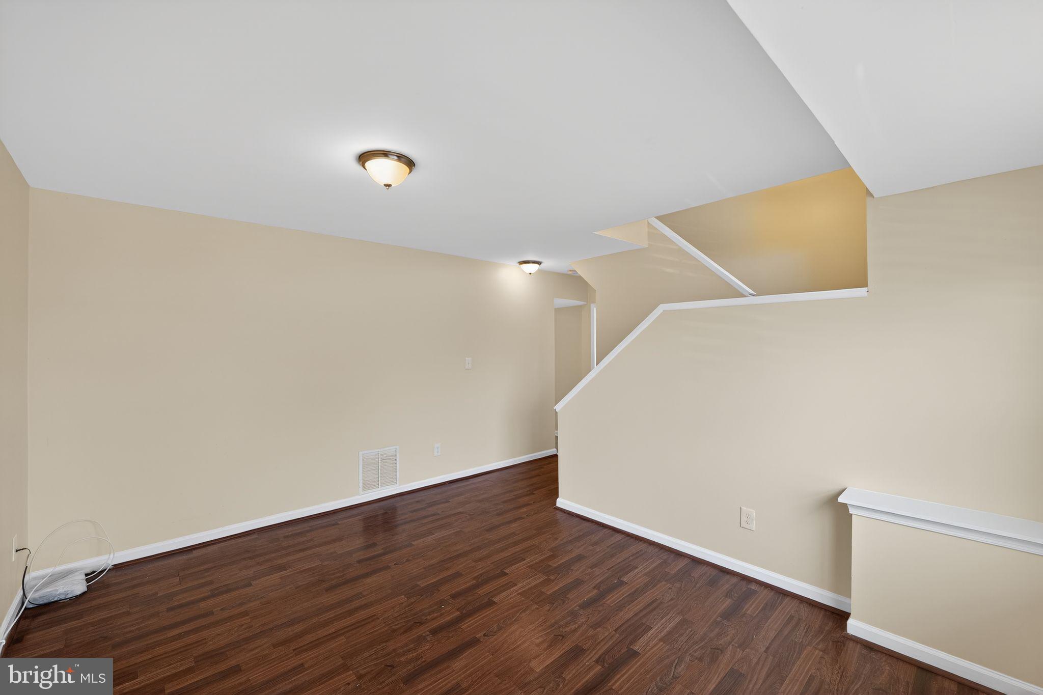 8090 Round Table Court Pasadena, MD 21122 - Photo 7 of 31 a view of an empty room with wooden floor