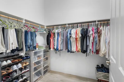 a view of walk in closet with clothes