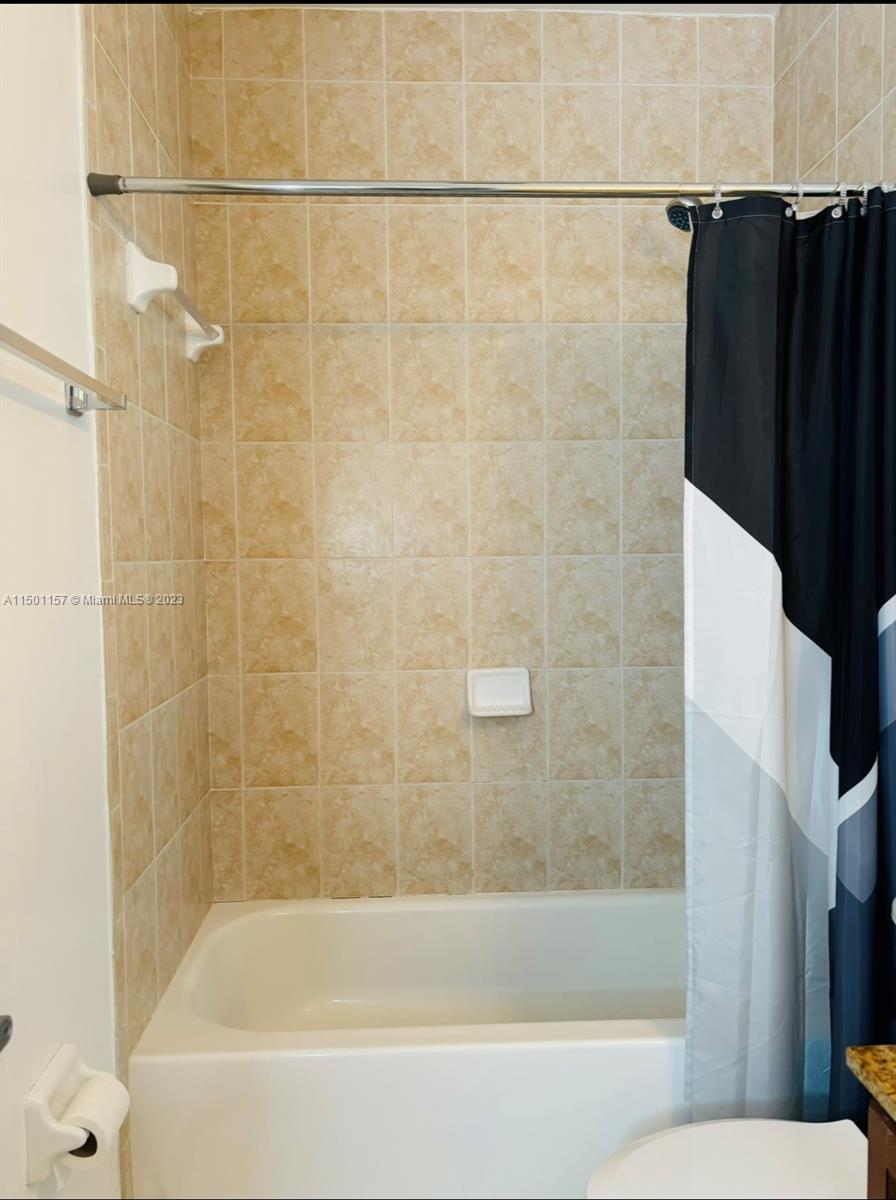 11115 West Okeechobee Road, Unit 181 Hialeah Gardens, FL 33018 - Photo 24 of 31 a bathroom with a bathtub and a shower
