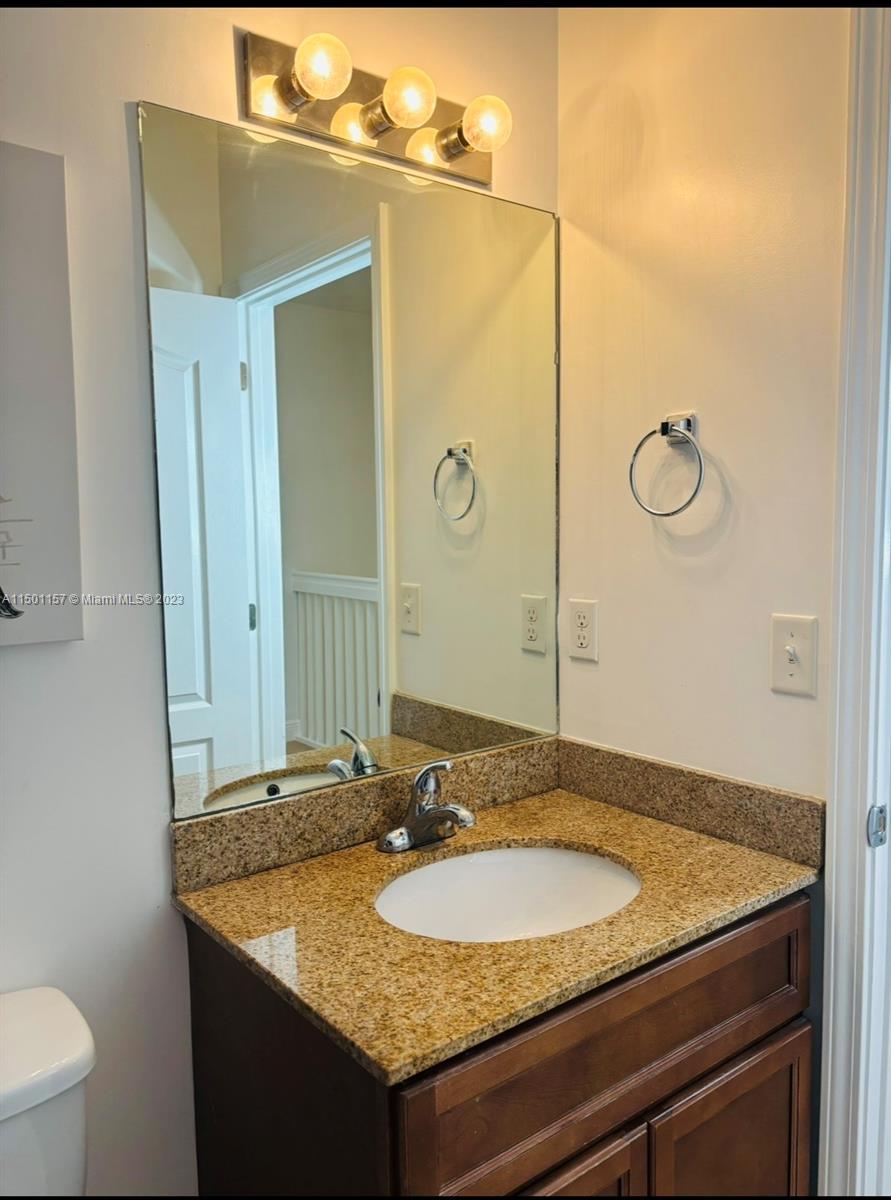 11115 West Okeechobee Road, Unit 181 Hialeah Gardens, FL 33018 - Photo 25 of 31 a bathroom with a granite countertop sink and a mirror