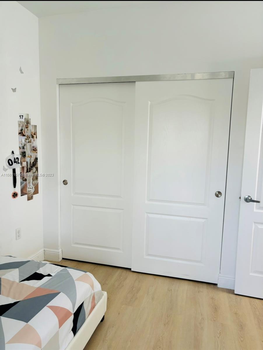 11115 West Okeechobee Road, Unit 181 Hialeah Gardens, FL 33018 - Photo 28 of 31 a bedroom with a bed and hallway