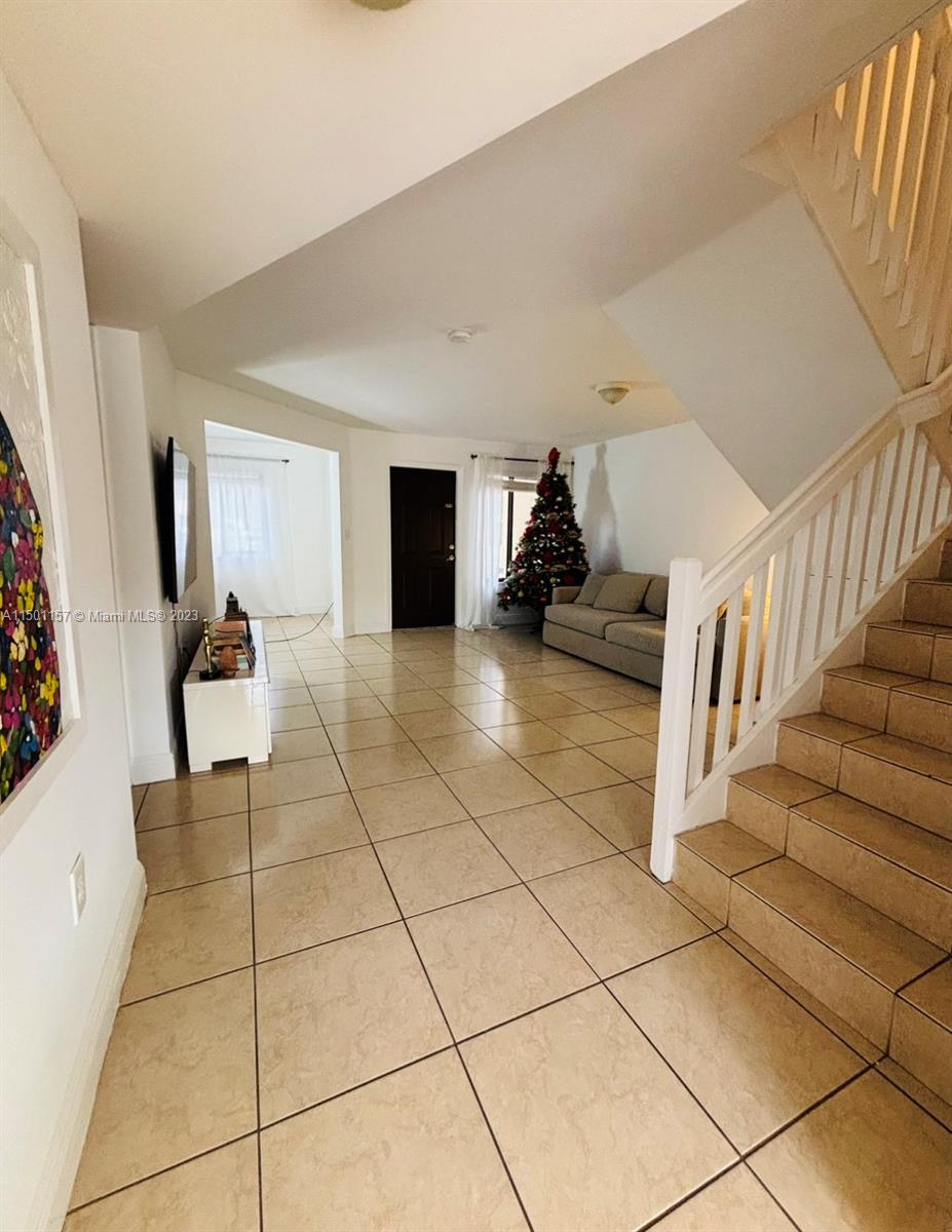 11115 West Okeechobee Road, Unit 181 Hialeah Gardens, FL 33018 - Photo 4 of 31 a view of a livingroom with entryway and stairs
