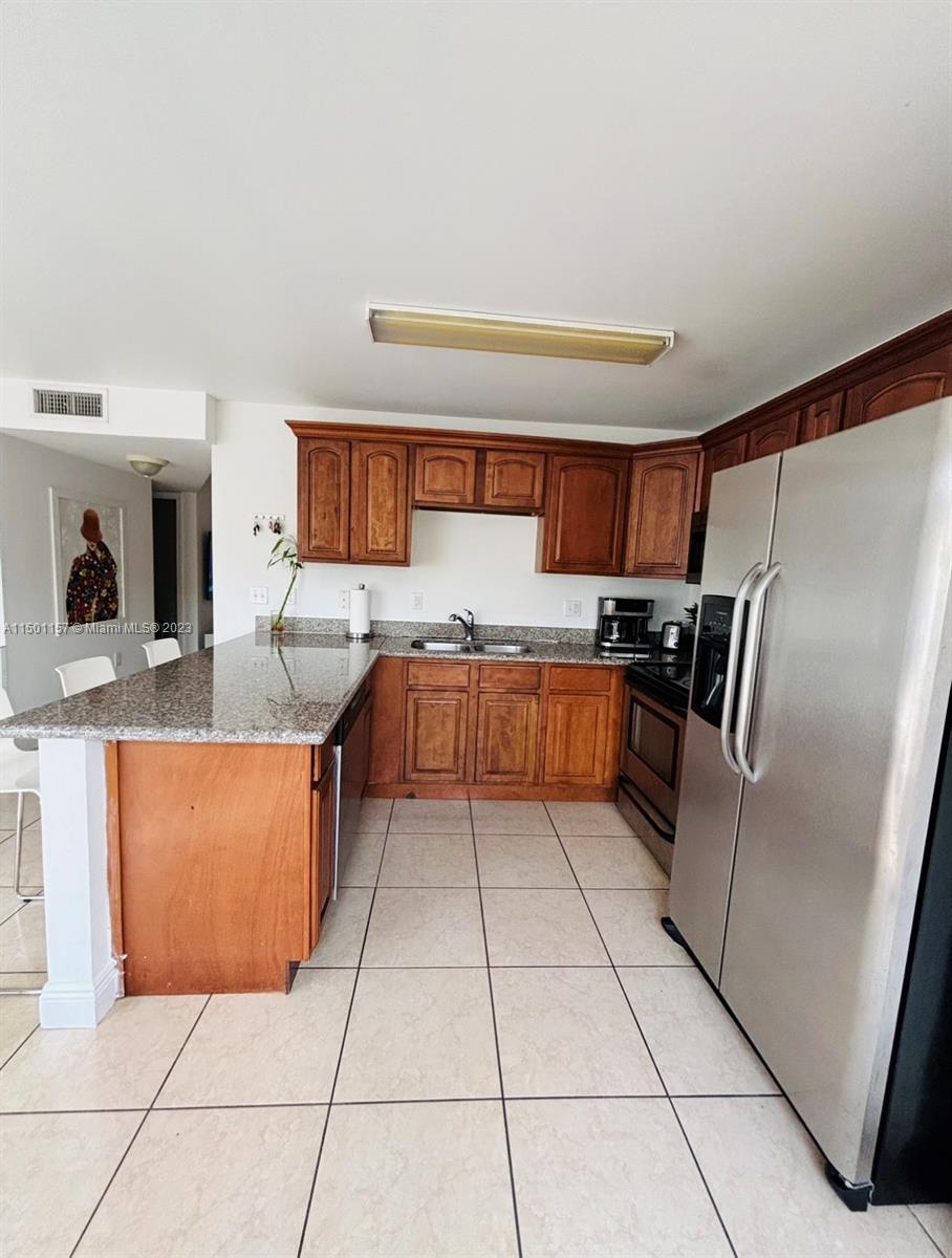 11115 West Okeechobee Road, Unit 181 Hialeah Gardens, FL 33018 - Photo 8 of 31 a kitchen with stainless steel appliances granite countertop a refrigerator and a stove top oven