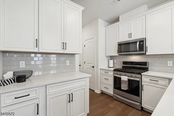 a kitchen with white cabinets and appliances