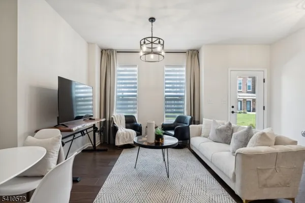 a living room with furniture wooden floor and a window