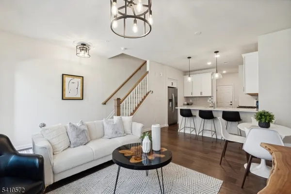 a living room with furniture a rug and kitchen view