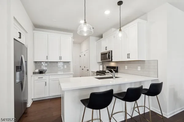 a kitchen with a center island white cabinets and stainless steel appliances