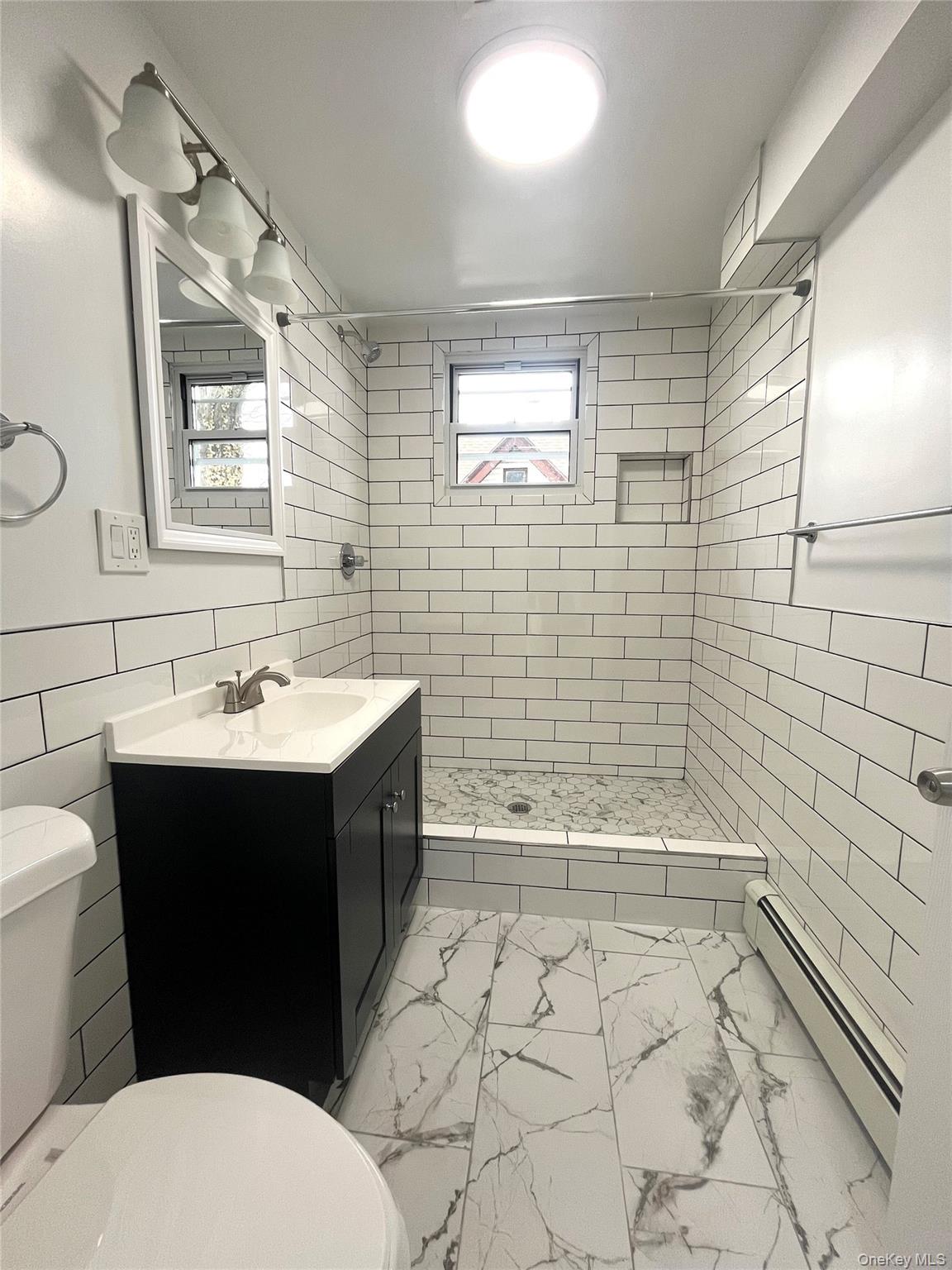 123 Clinton Avenue, Unit 2 New Rochelle, NY 10801 - Photo 11 of 27 a bathroom with a sink a toilet and shower