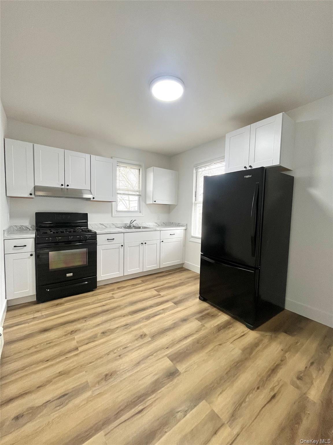 123 Clinton Avenue, Unit 2 New Rochelle, NY 10801 - Photo 3 of 27 a kitchen with a refrigerator and a stove top oven