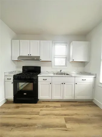 a kitchen with granite countertop white cabinets and white appliances