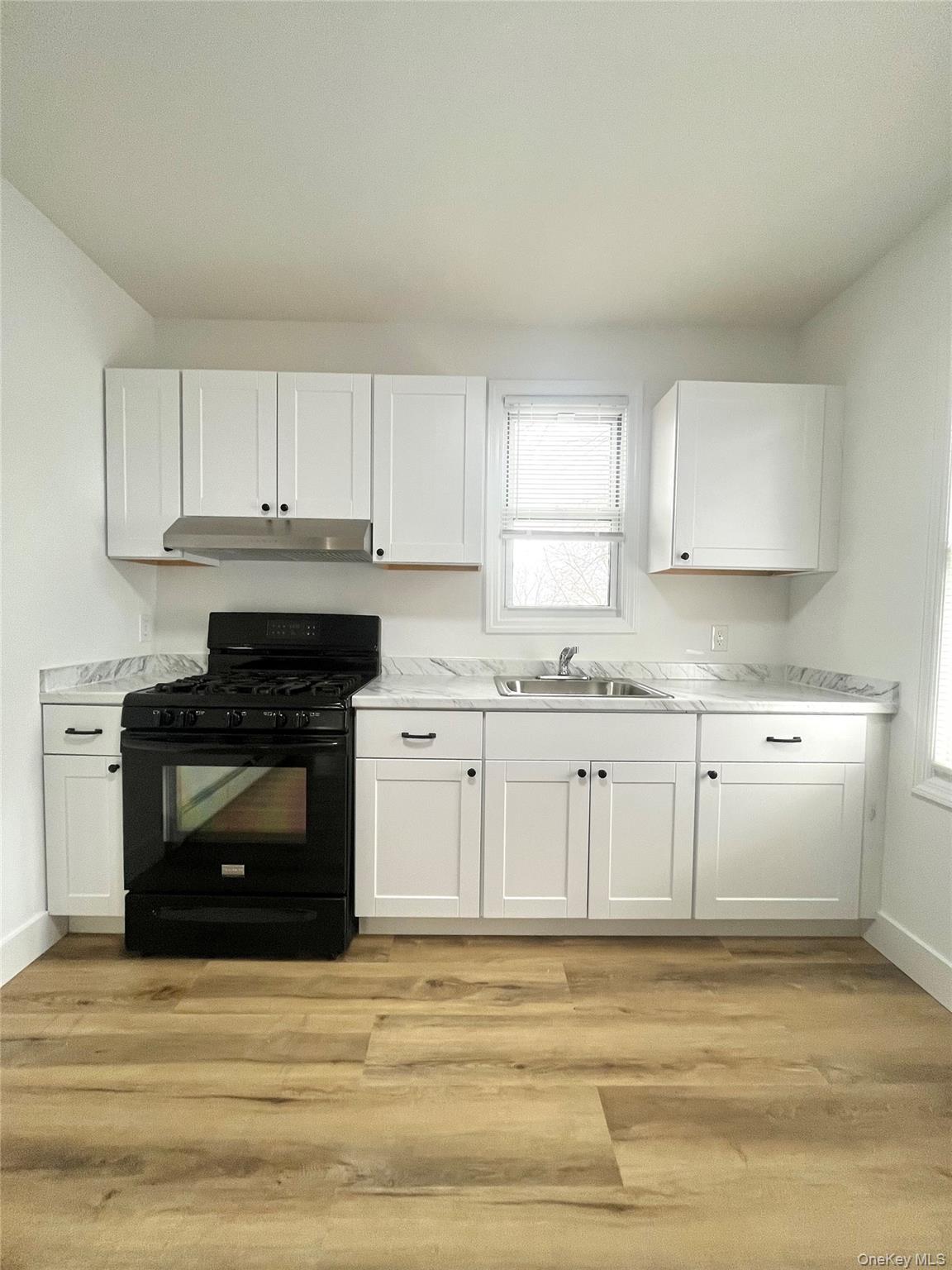 123 Clinton Avenue, Unit 2 New Rochelle, NY 10801 - Photo 4 of 27 a kitchen with granite countertop white cabinets and white appliances