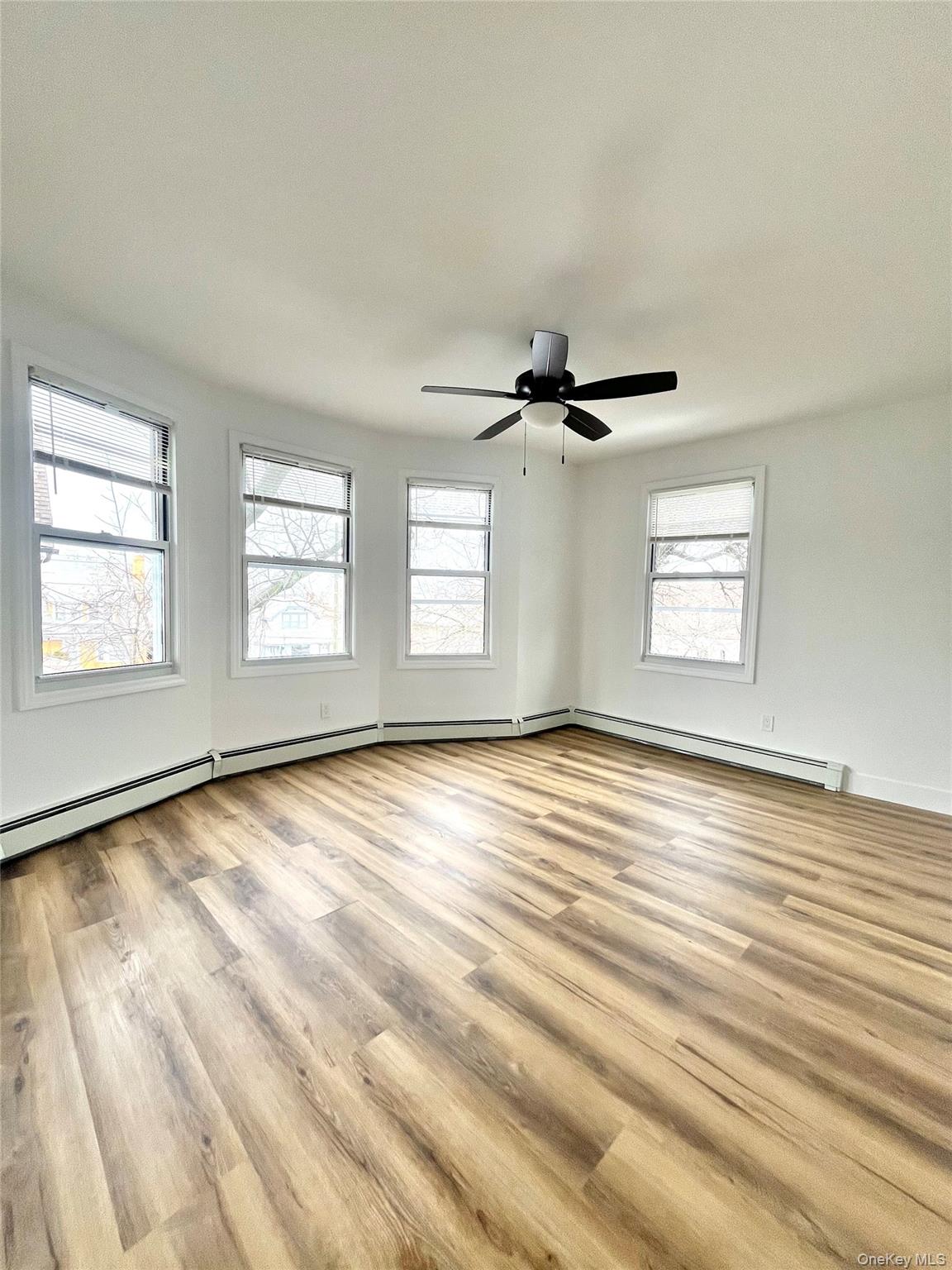 123 Clinton Avenue, Unit 2 New Rochelle, NY 10801 - Photo 5 of 27 a view of empty room with wooden floor and fan