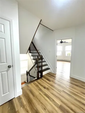 a view of a hallway with wooden floor and entryway