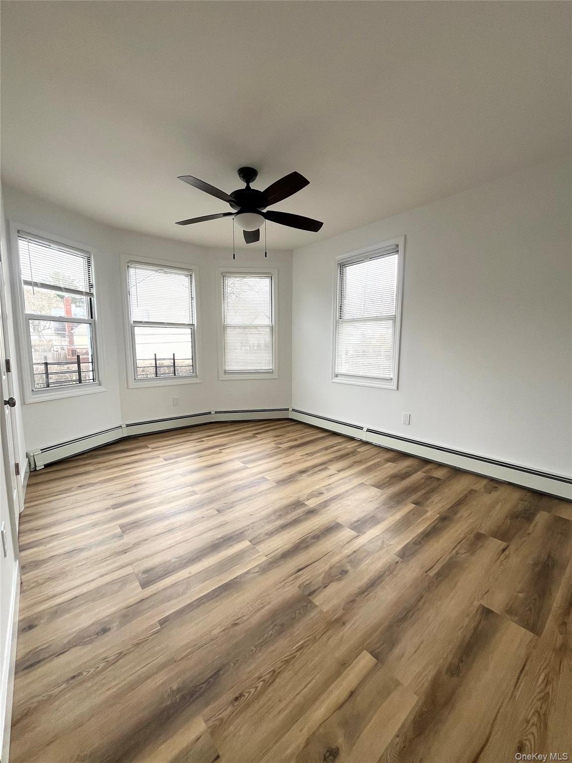 123 Clinton Avenue, Unit 2 New Rochelle, NY 10801 - Photo 7 of 27 an empty room with wooden floor and windows