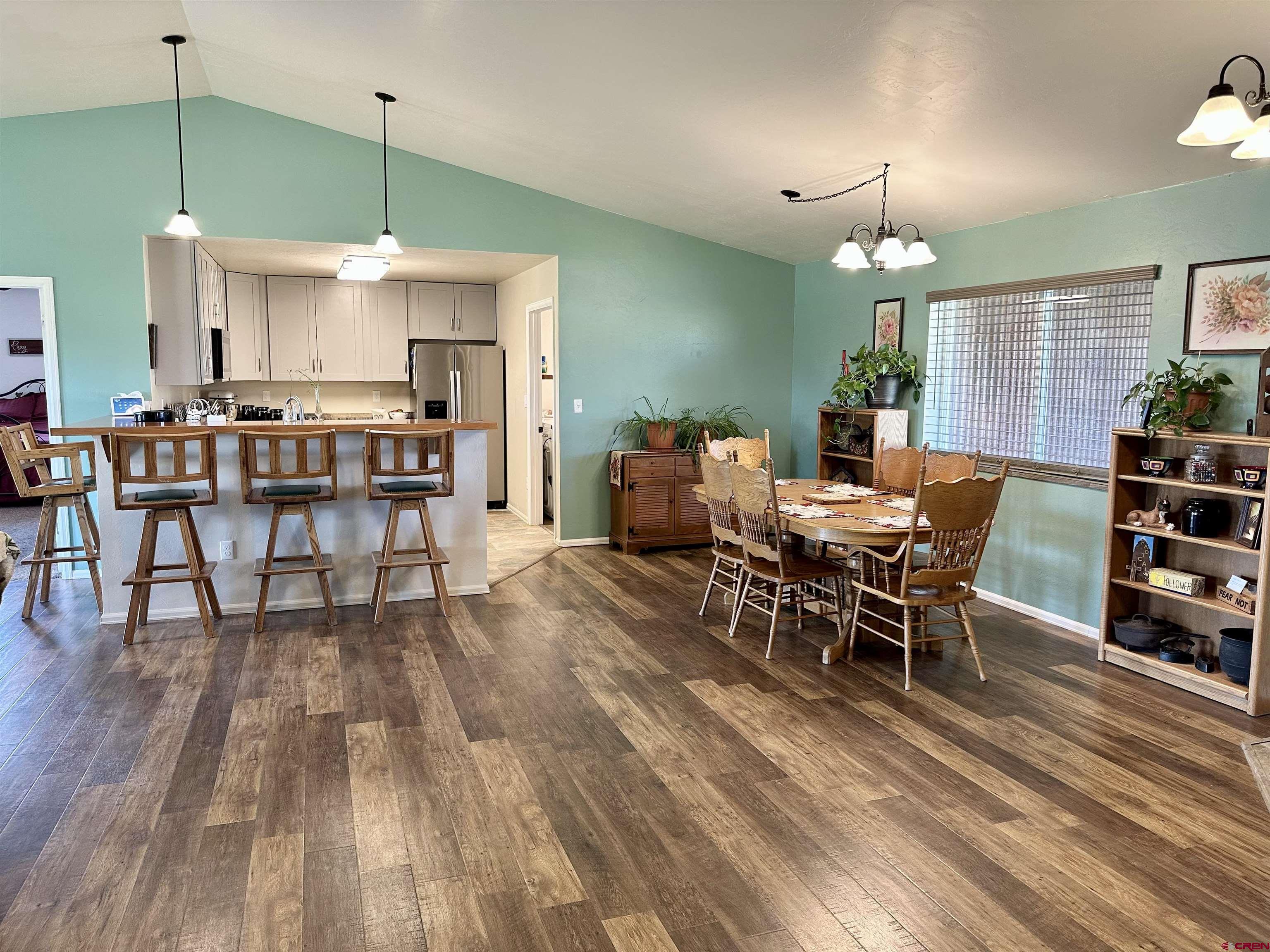 8352 2000th Road Austin, CO 81410 - Photo 3 of 35 a dining room with wooden floor a chandelier a wooden table and chairs
