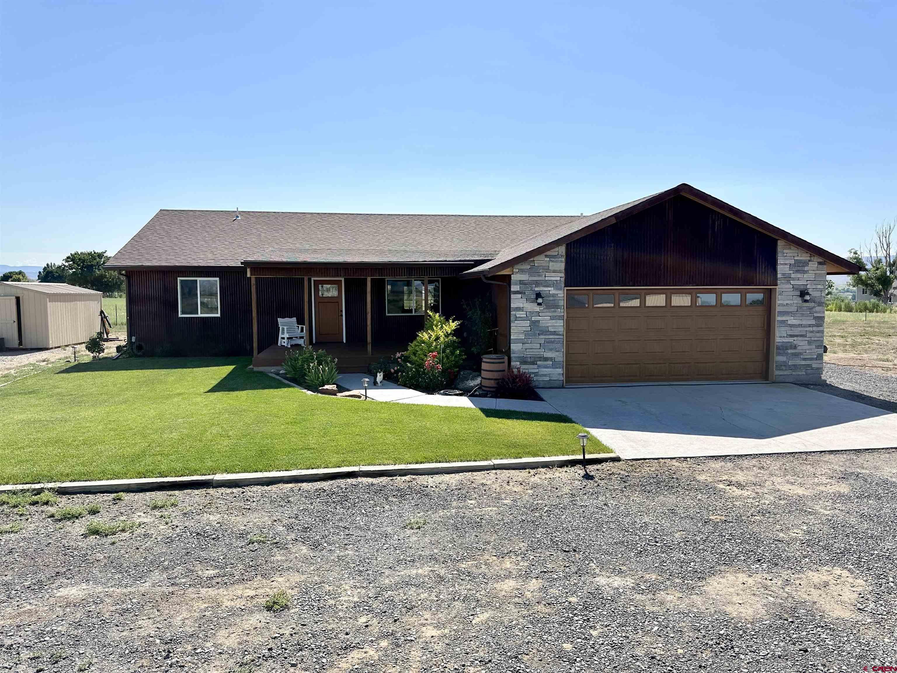 8352 2000th Road Austin, CO 81410 - Photo 33 of 35 a front view of a house with a yard and garage