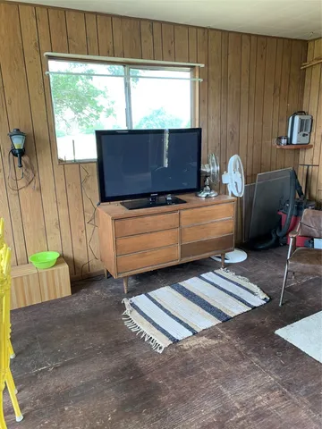a living room with furniture a window and a flat screen tv