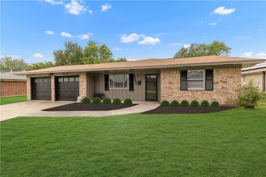 a front view of a house with a garden and yard