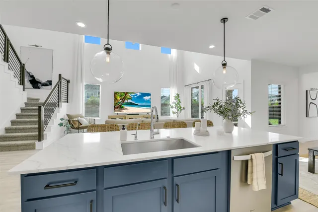 a kitchen with stainless steel appliances kitchen island granite countertop a sink and refrigerator