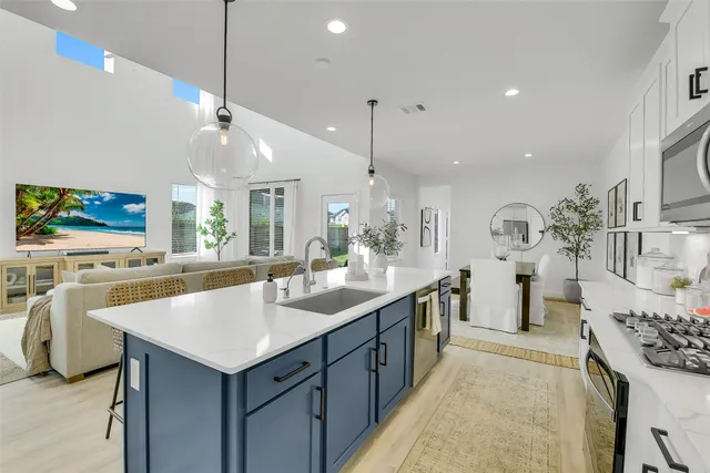 a room with kitchen island a sink and a large mirror with wooden floor