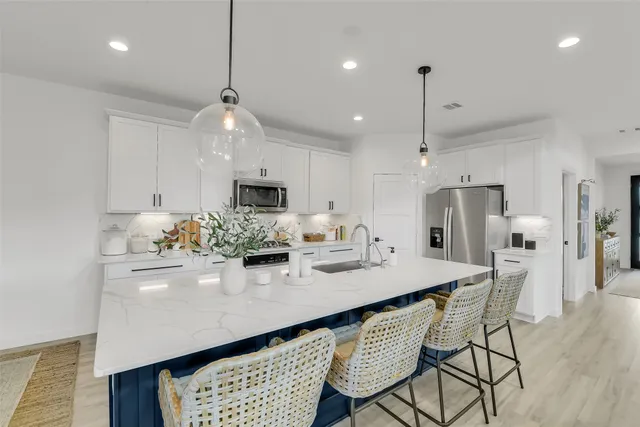 a large kitchen with kitchen island a sink appliances and a counter top space