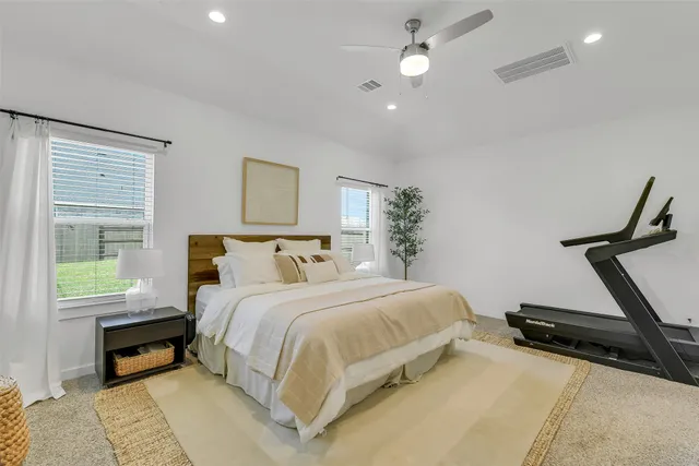 a spacious bedroom with a bed and a dresser