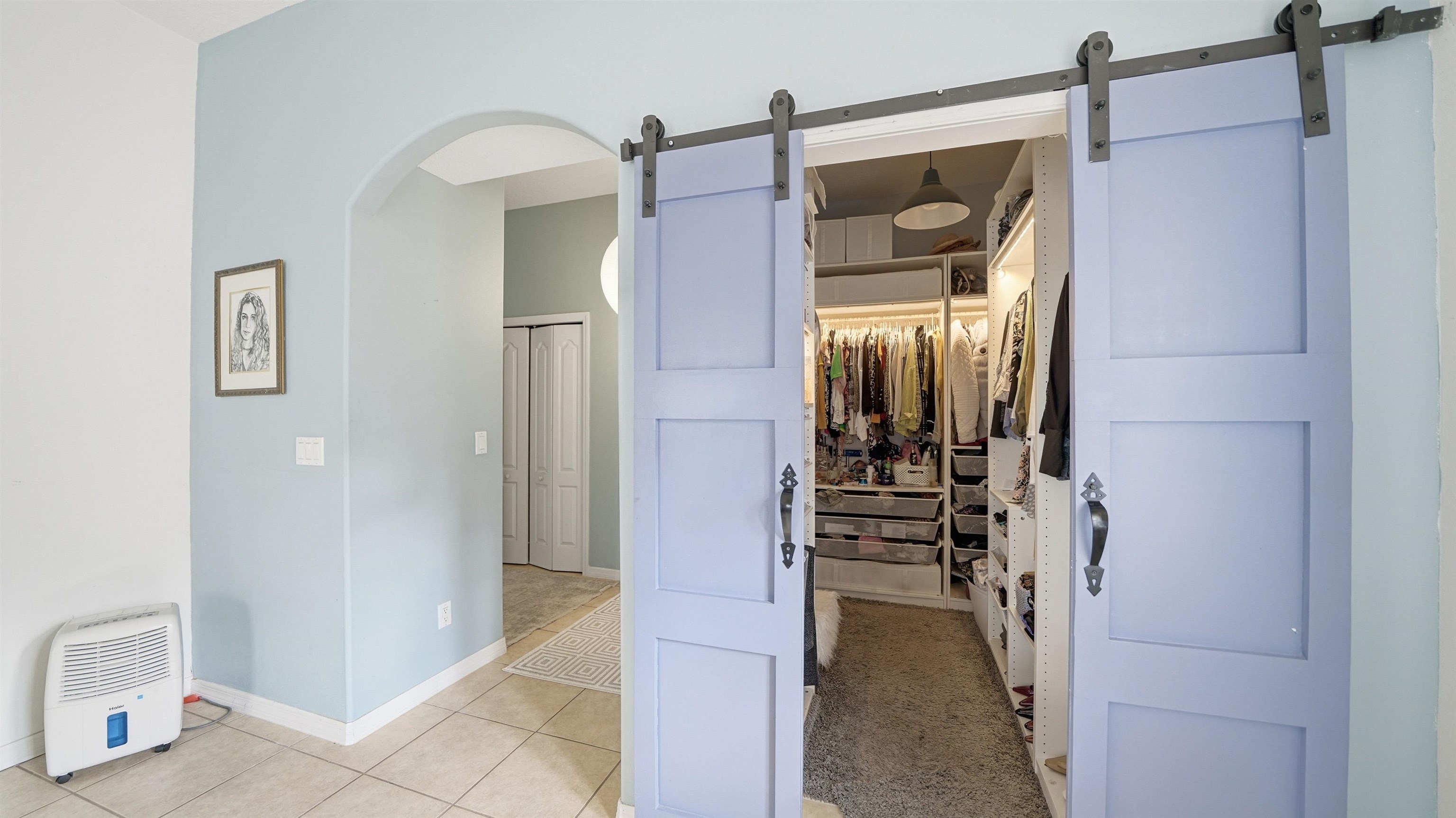 22 Flanders Lane Palm Coast, FL 32137 - Photo 16 of 70 Spacious closet with a barn door, light tile patterned floors, and arched walkways