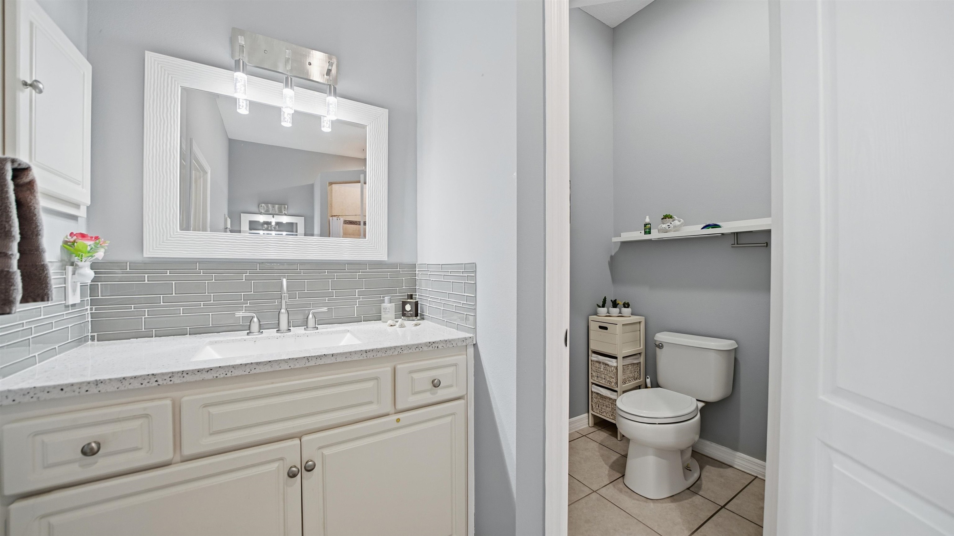 22 Flanders Lane Palm Coast, FL 32137 - Photo 19 of 70 Bathroom featuring backsplash, vanity, and light tile patterned floors