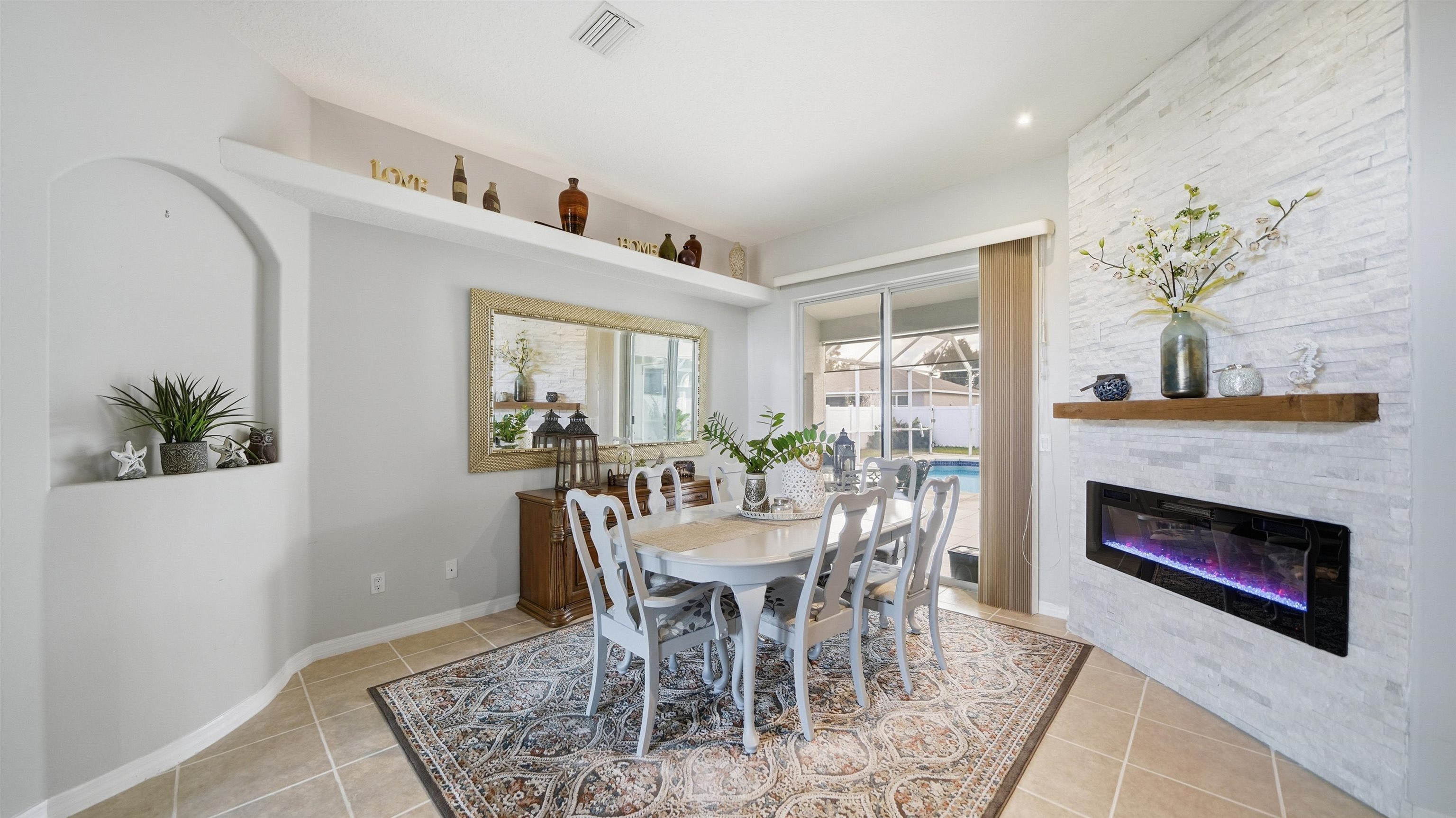 22 Flanders Lane Palm Coast, FL 32137 - Photo 22 of 70 a dining room with furniture a floor to ceiling window and a fireplace
