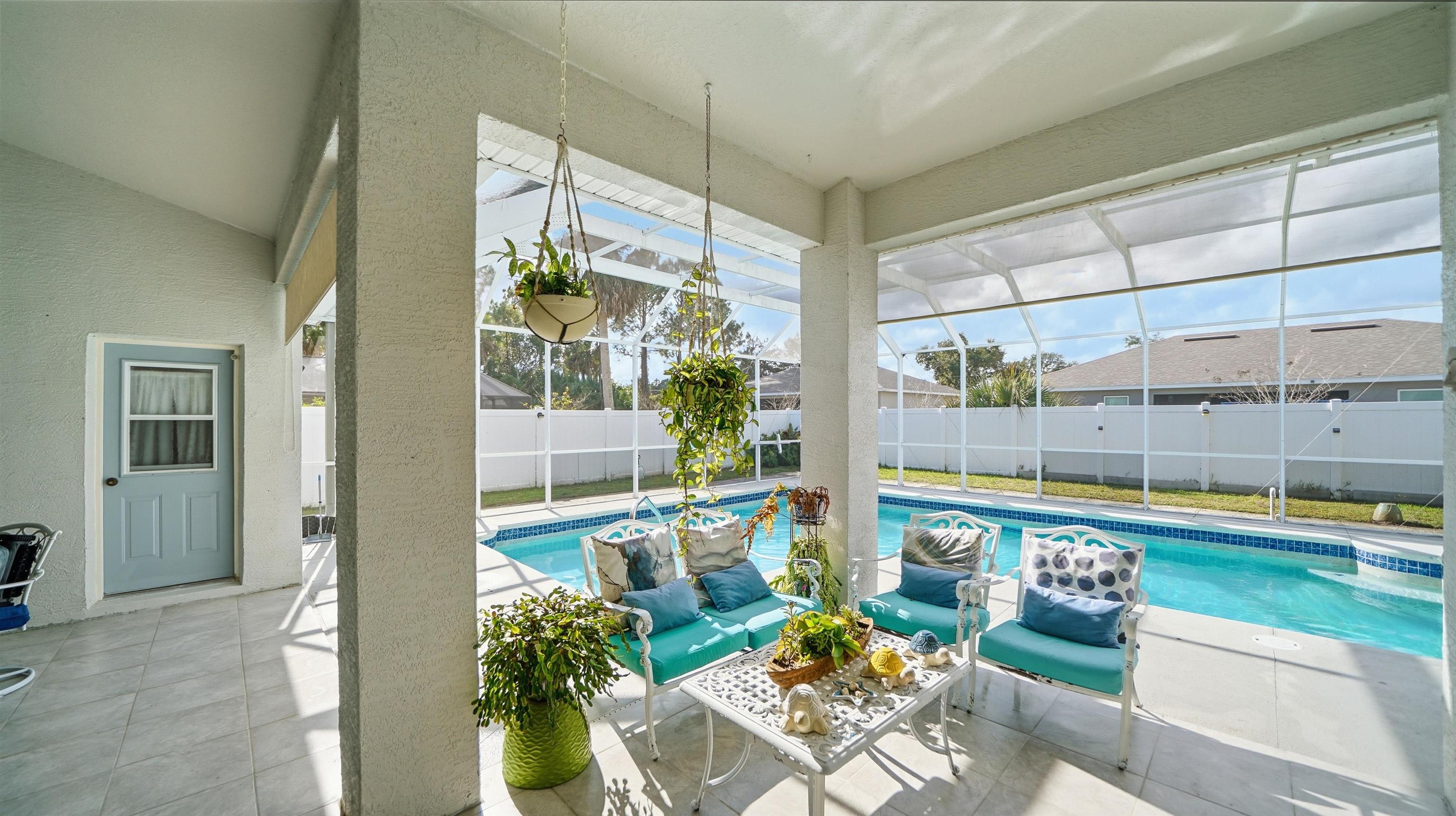 22 Flanders Lane Palm Coast, FL 32137 - Photo 44 of 70 View of swimming pool featuring a lanai, a sunroom, a patio, and a fenced backyard