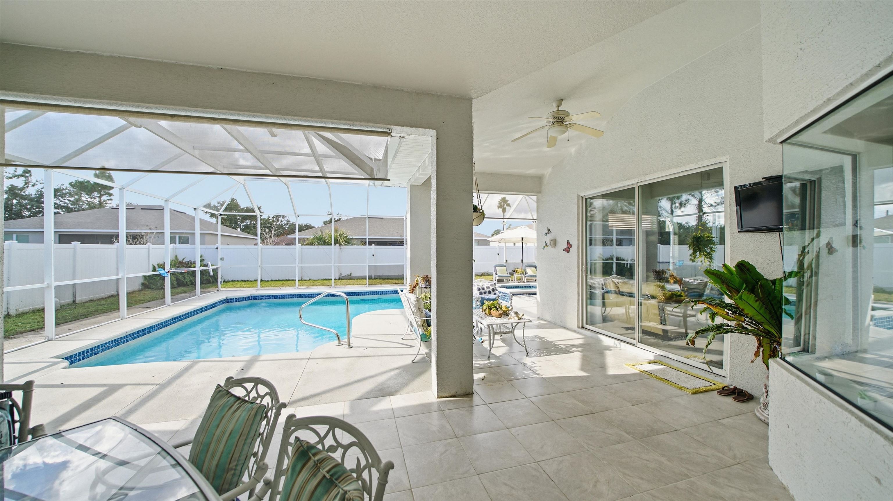 22 Flanders Lane Palm Coast, FL 32137 - Photo 48 of 70 View of swimming pool with glass enclosure, a fenced backyard, a sunroom, and a patio