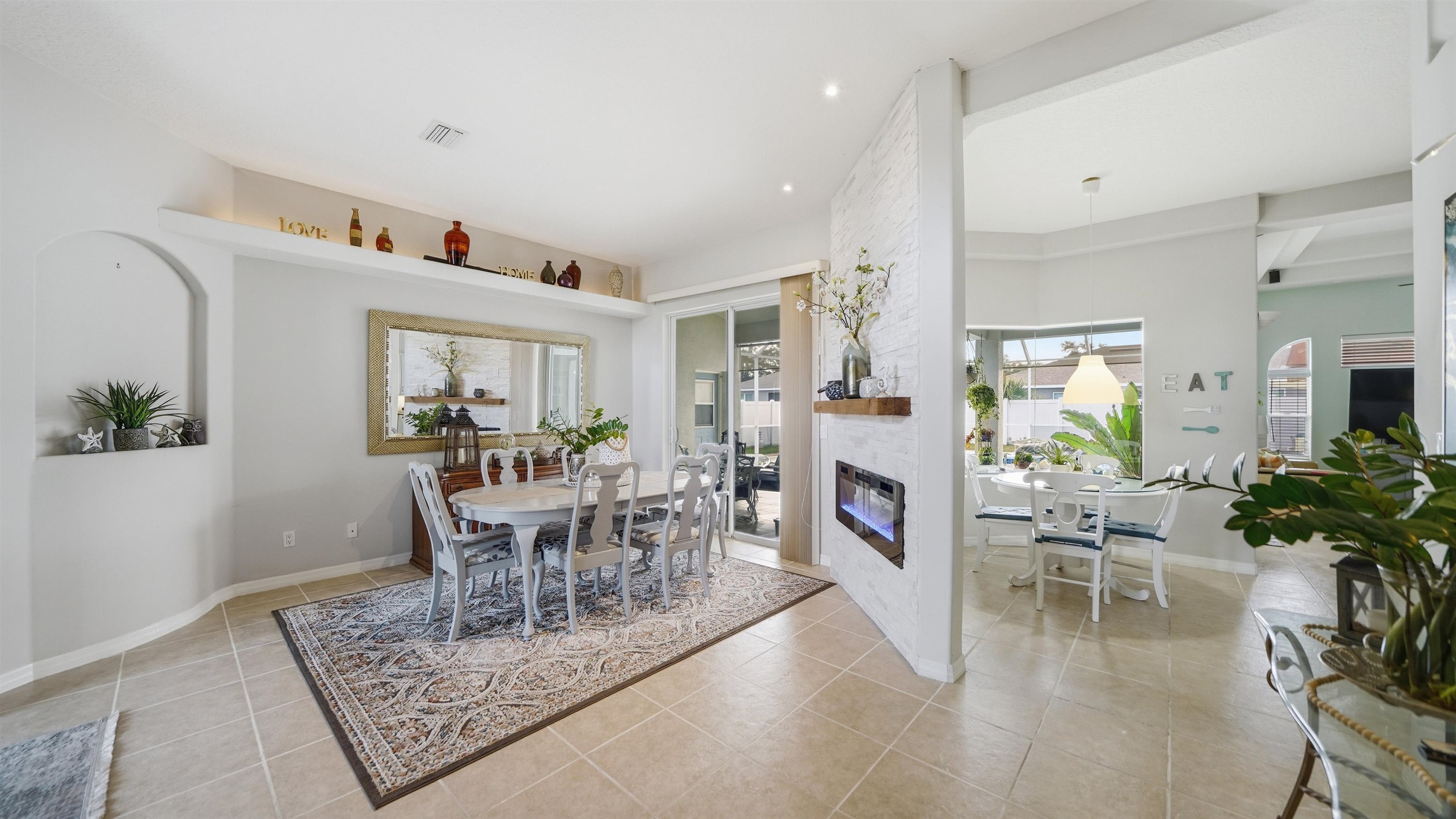 22 Flanders Lane Palm Coast, FL 32137 - Photo 5 of 70 a dining room with furniture a fireplace and wooden floor