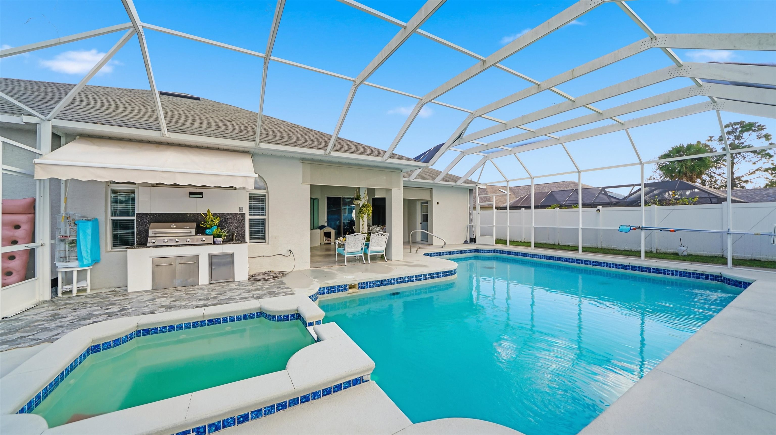 22 Flanders Lane Palm Coast, FL 32137 - Photo 55 of 70 View of pool featuring glass enclosure, a sunroom, a patio, exterior kitchen, and a pool with connected hot tub