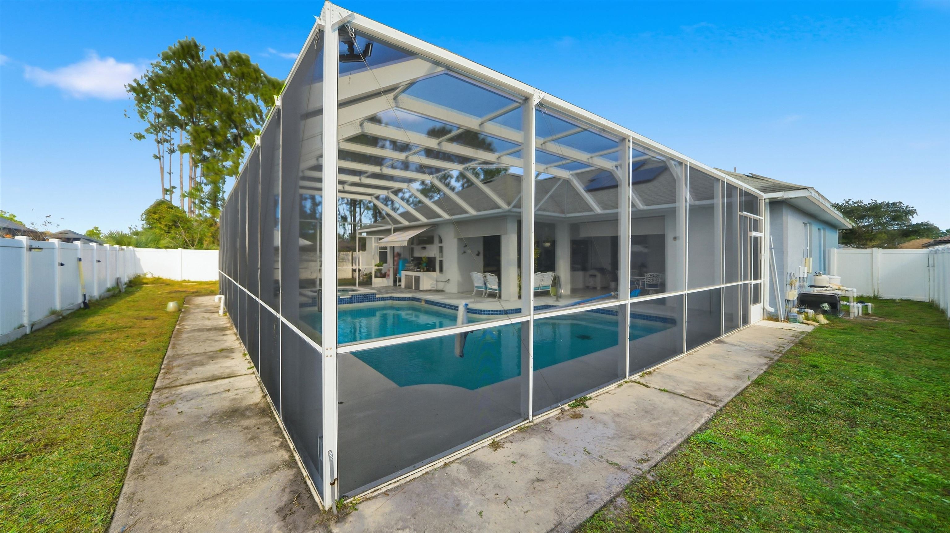 22 Flanders Lane Palm Coast, FL 32137 - Photo 57 of 70 View of swimming pool featuring a fenced backyard, a sunroom, a lanai, and a patio area