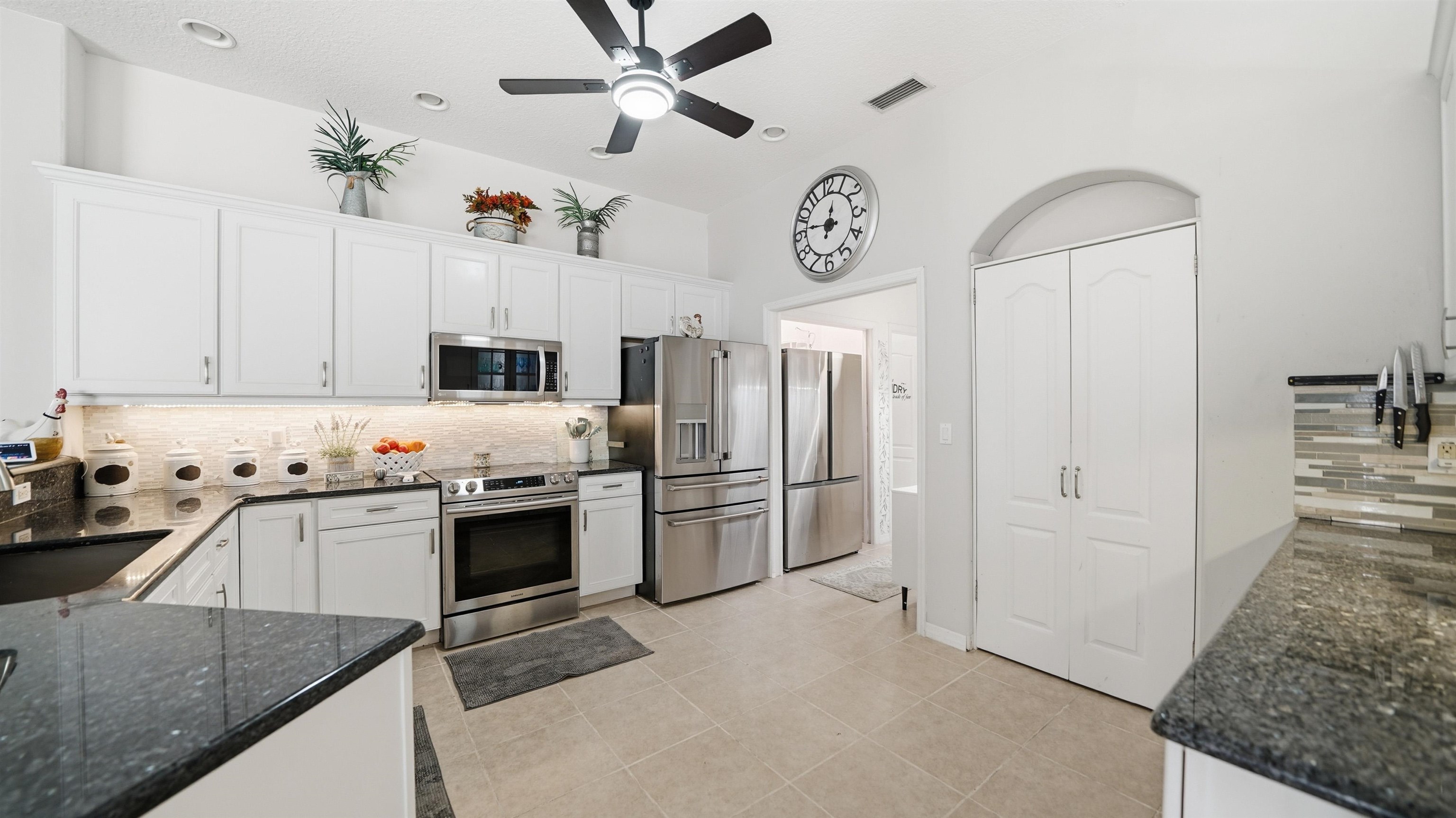 22 Flanders Lane Palm Coast, FL 32137 - Photo 7 of 70 a kitchen with stainless steel appliances granite countertop a refrigerator a stove and a sink
